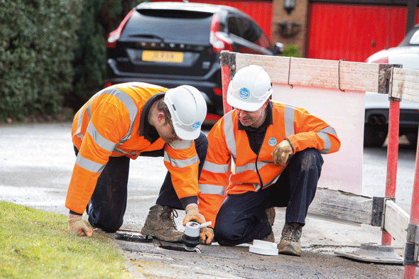 Thames workers looking at smart meter reading on road