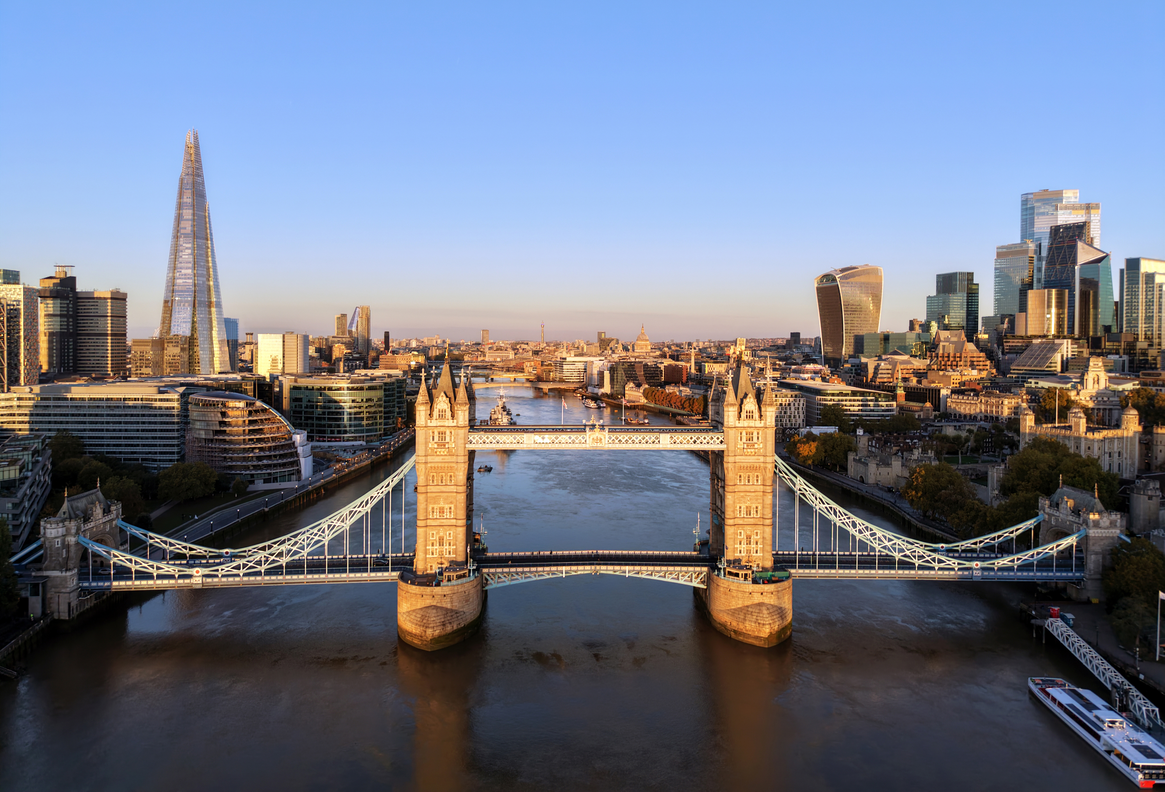 A sunrise view over the River Thames includes Tower Bridge and the Shard.