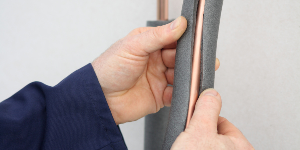person insulating pipes