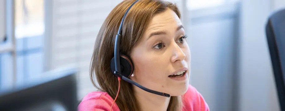 A lady in a call centre with a headset on
