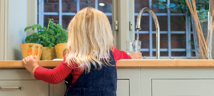 A child filling up a glass of tap water