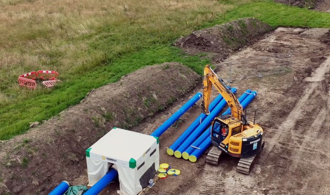 Pipeline and machinery pictured in a rural field