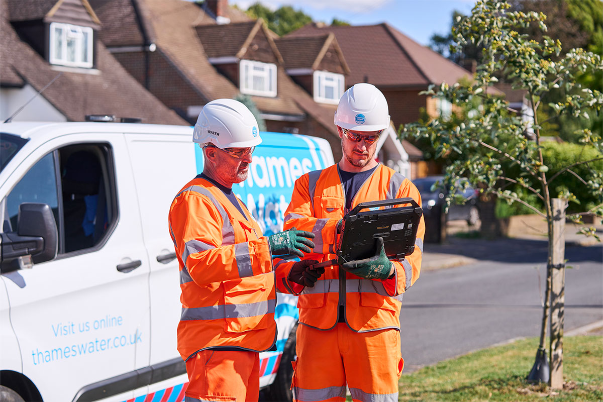 two engineers using handheld near van in engineer