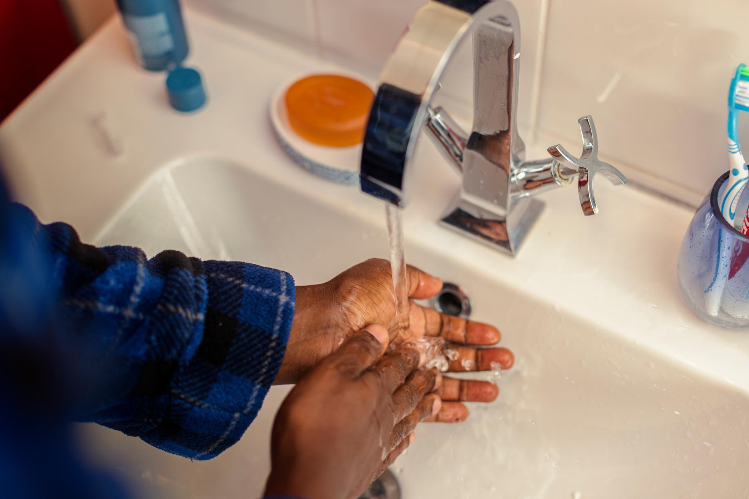Engineer washing their hands under the tap