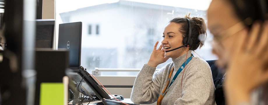 A woman in an office with a headset on