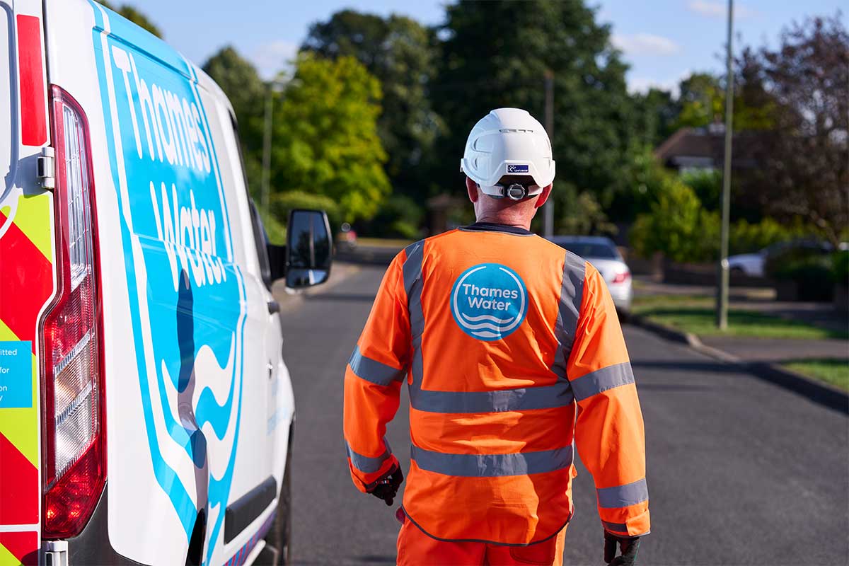 Thames Water engineer walking down street next to van