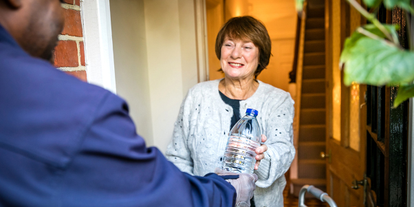 Customer receiving bottled water from Thames Water employee