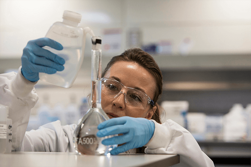 A water analyst filling a volumetric flask