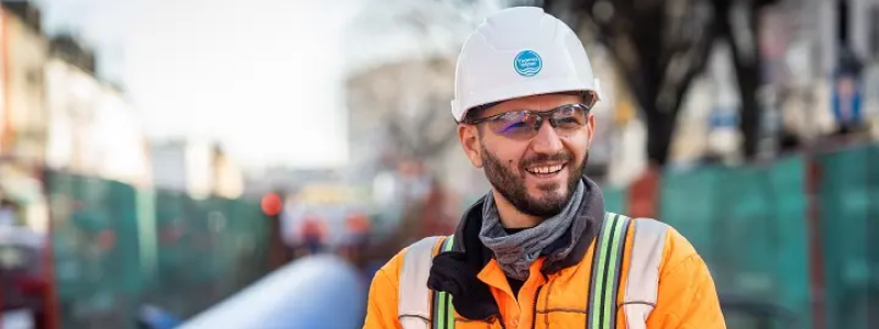A close up of a smiling Thames Worker wearing a hard hat