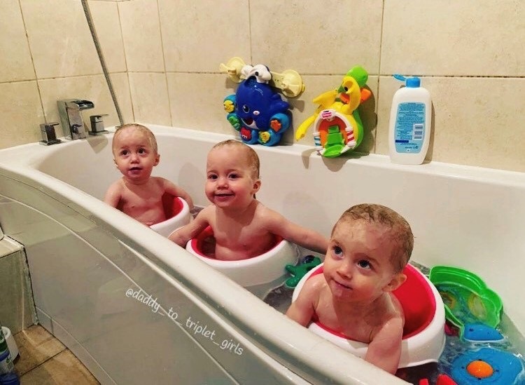 Three babies sitting in a bathtub