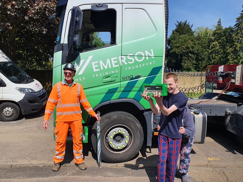 Mitchell Sterne being presented with a scale model crane infront of Emerson delivery truck
