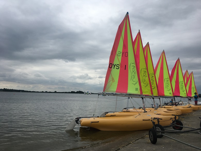 sailing boats on a reservoir under cloudy skies