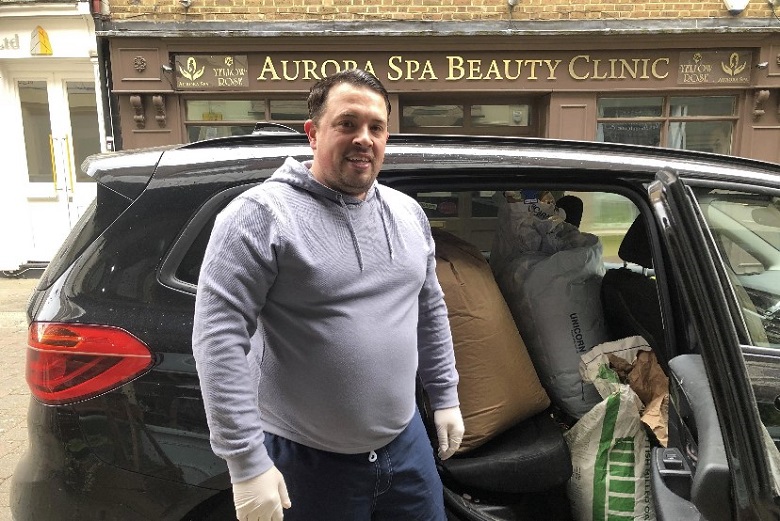 Dean Vine standing with a car full of food for delivery.