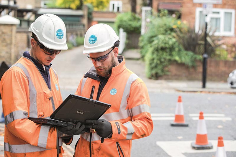 Two engineers in the field using a laptop