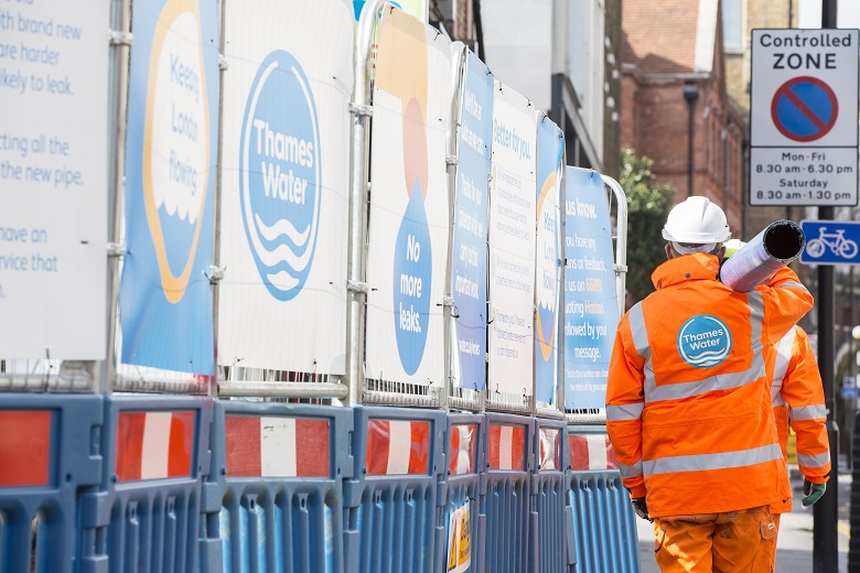 Thames Water engineers carrying a water pipe