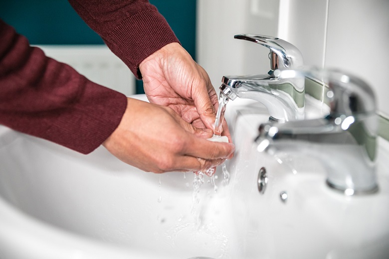 hands being washed at bathroom sink