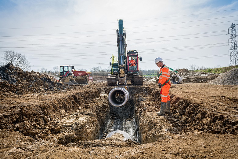 A section of sewer pipe is lowered into the ground at Chesterton Farm