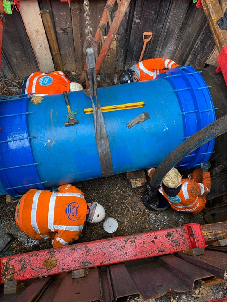 Thames Water engineers fit a section of water main