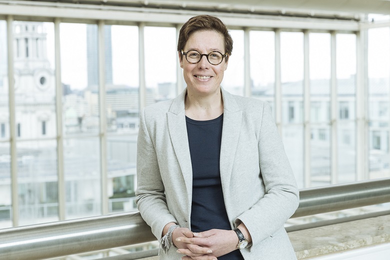 Woman wearing a grey jacket and glasses
