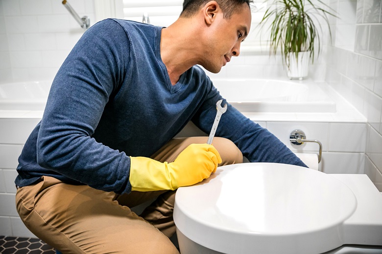 Plumber fixing a toilet