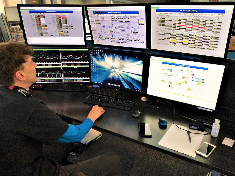 Man looks at bank of computer screens
