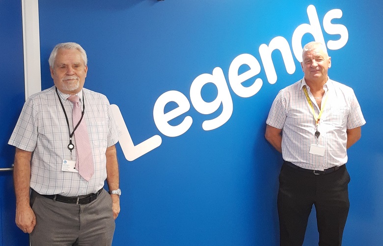 Stuart Morton and Dave Theobald stand against a wall