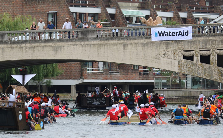 Groups of people on rafts paddling on the River Thames
