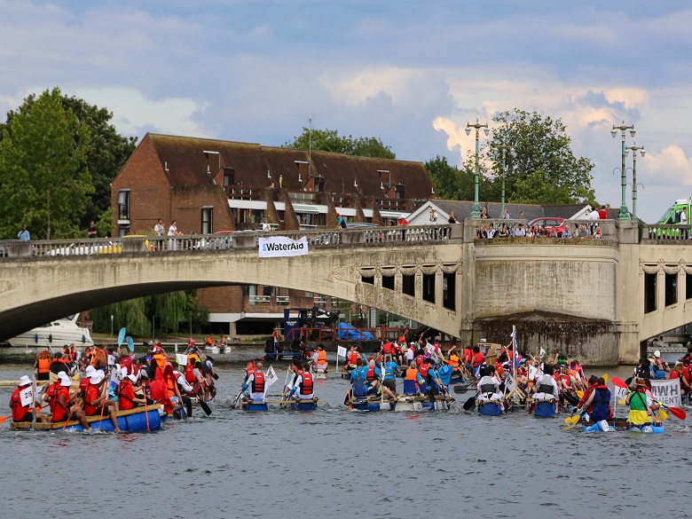 Thames water employees racing on rafts on river Thames 