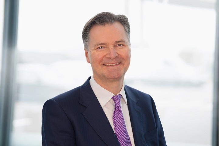 John Holland-Kaye wearing suit and purple tie