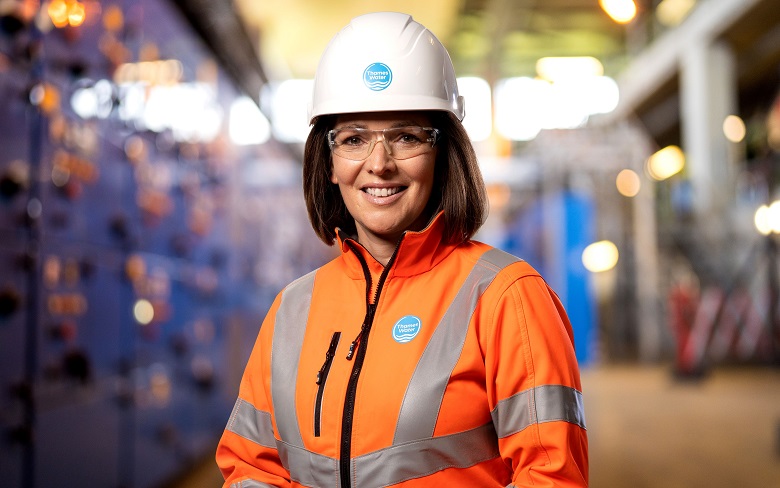 Sarah Bentley Thames Water CEO wearing an orange high vis jacket and a white hard hat.