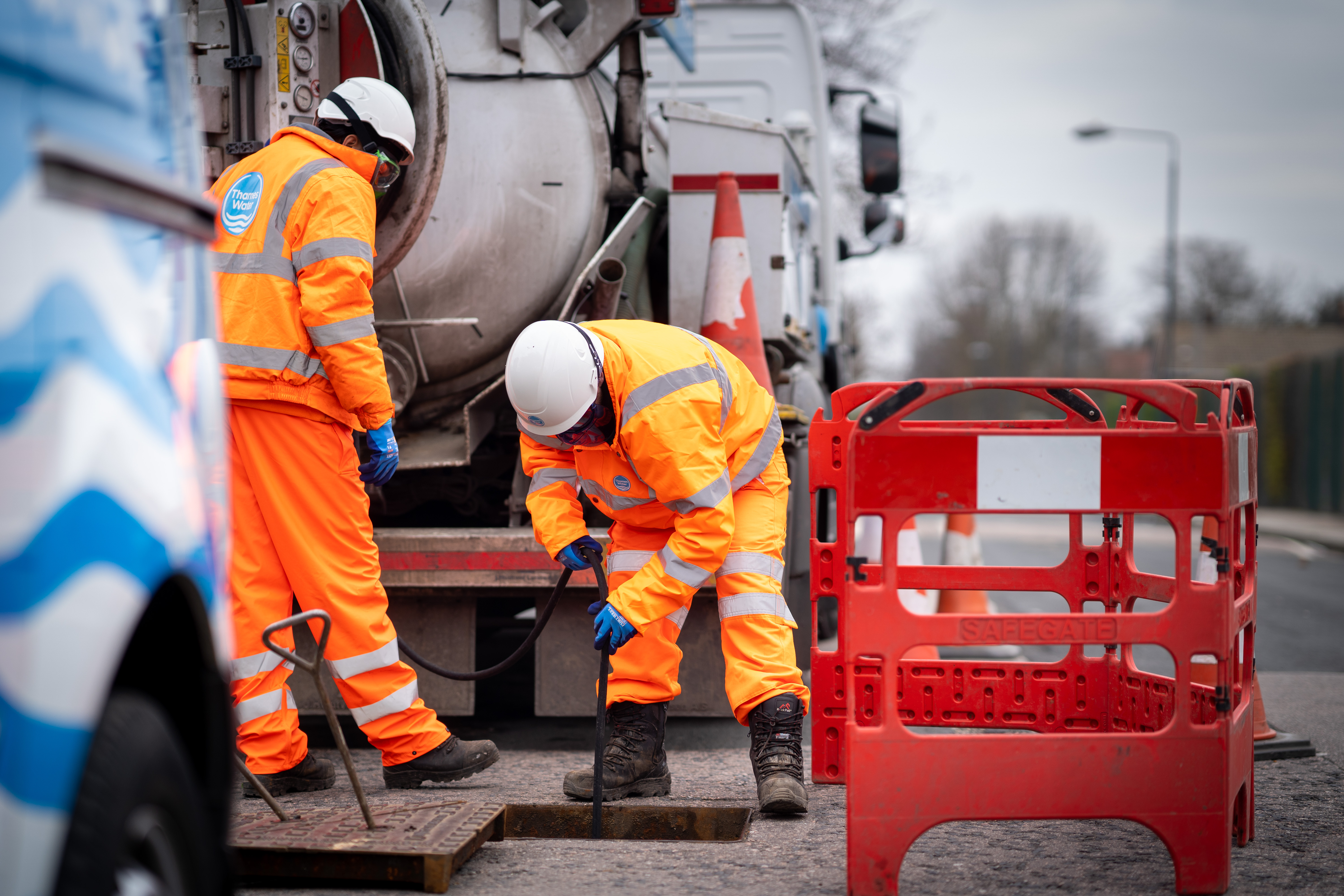 Two Thames Water engineers using a jet to unblock a sewer