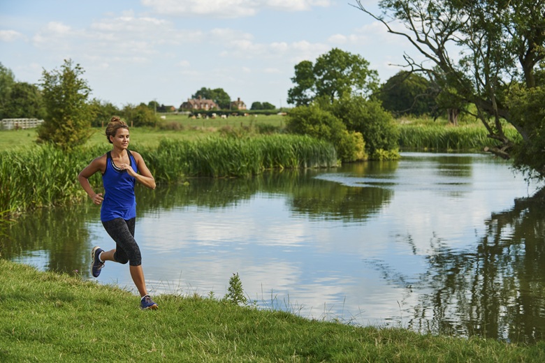 person runs along river bank