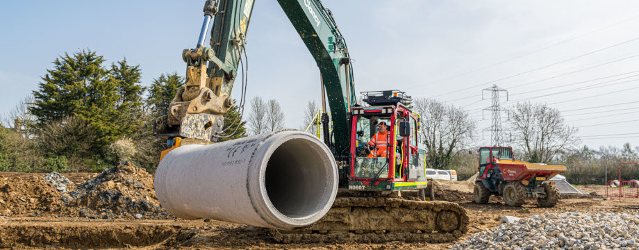 Crane lifting large pipe