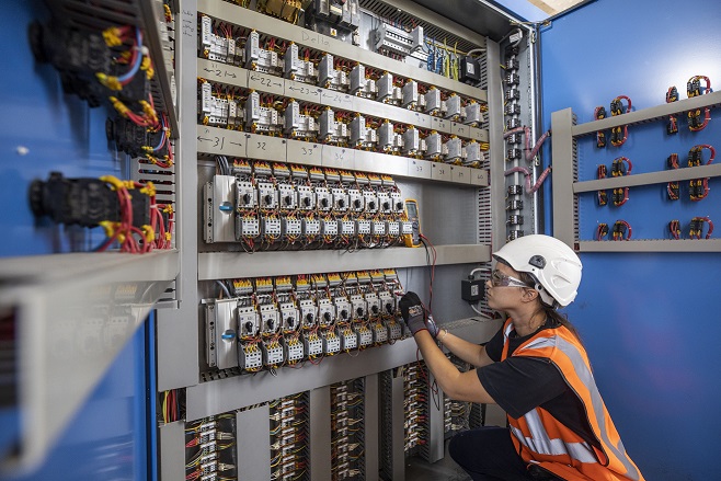 Photograph of technician working on control panel