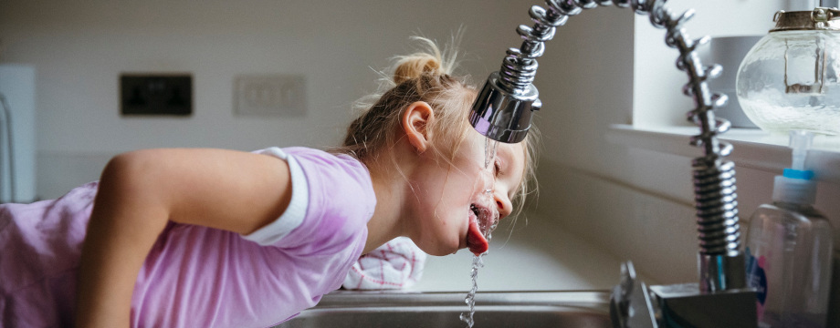 Child drinking water from tap