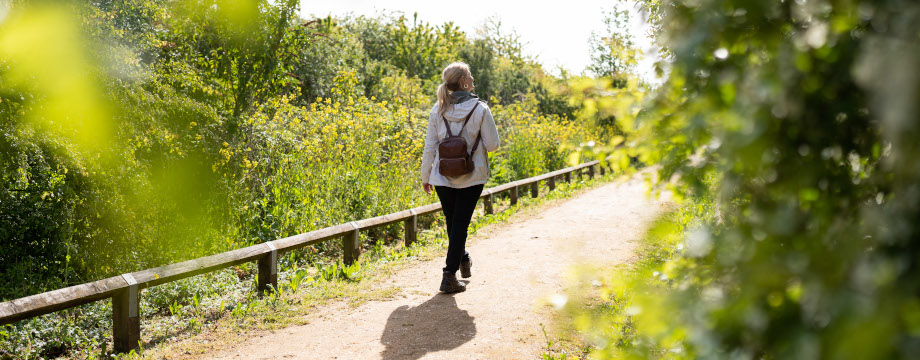 Woman walking down a path at Beckton nature reserve