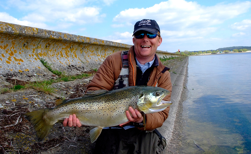 Fisherman with brown trout at Farmoor fishery
