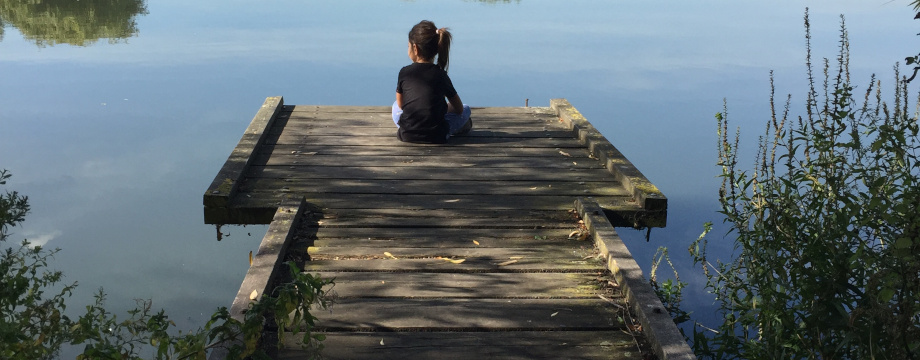 Child sitting on jetty at Walthamstow reservoir