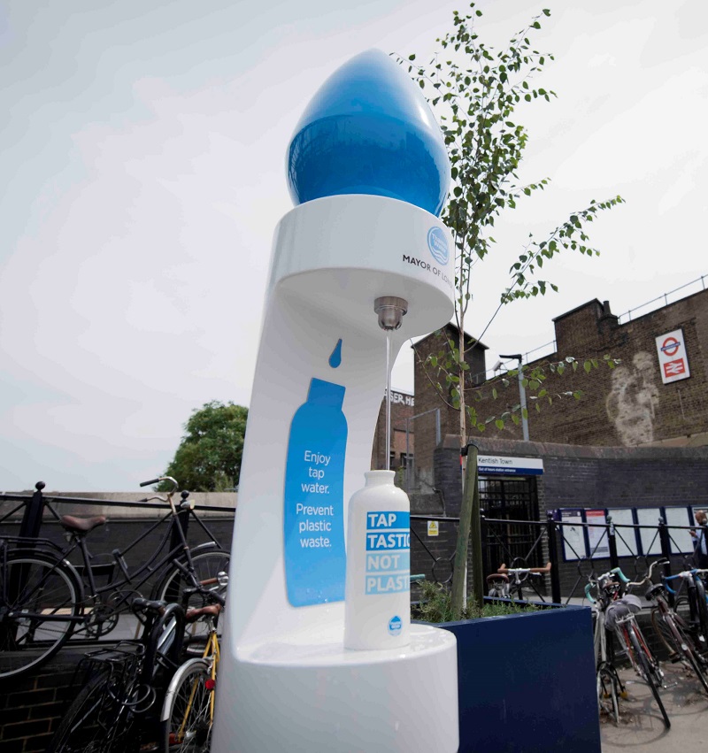 A picture of a white water fountain with a blue top in a London street.