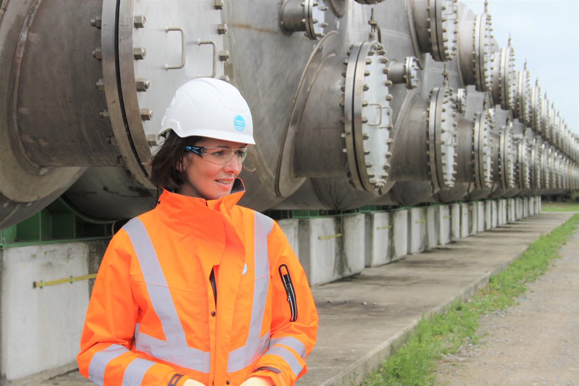 A picture of our CEO, Sarah Bentley, wearing an orange hi-vis jacket and white helmet with the Thames Water logo on.