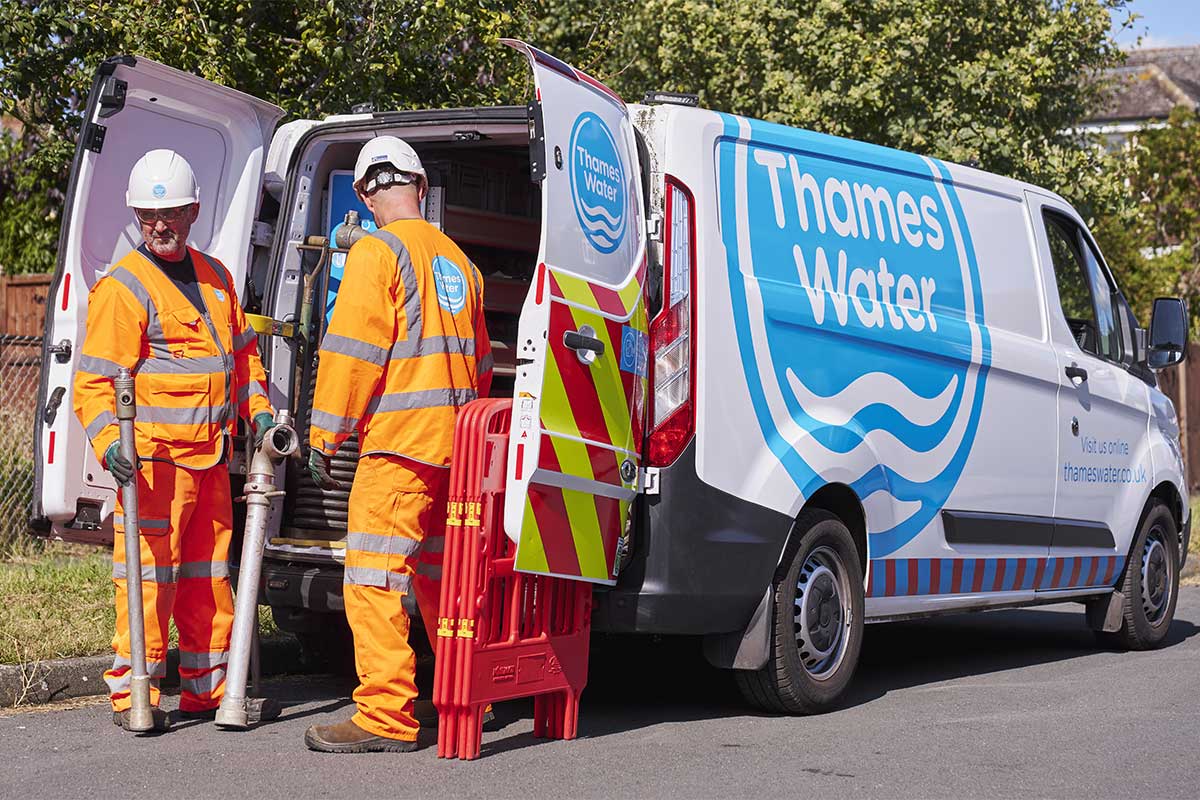 Two Thames Water engineers stood by a Thames Water van.