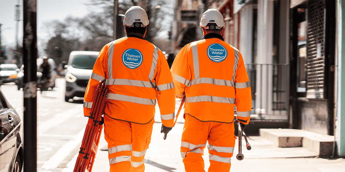 Two NSTs walking on a pavement to set up a work site.
