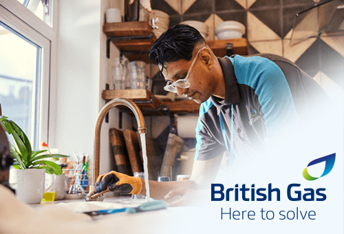 A man in British Gas uniform working at a sink with the tap running.