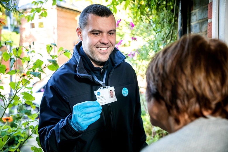 A Thames Water customer service rep showing their ID outside a customer's home