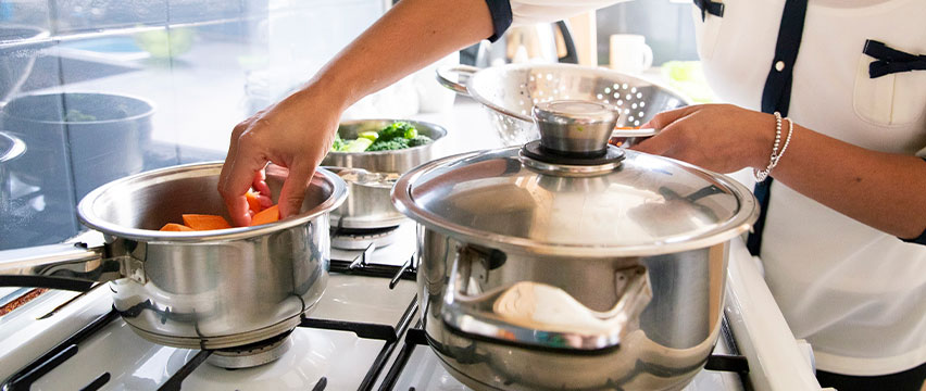 A person cooking vegetables in a pot
