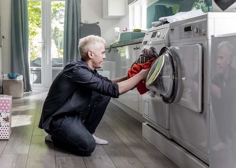 A person loading their washing machine