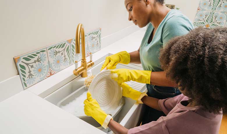 Mother and child washing up dishes