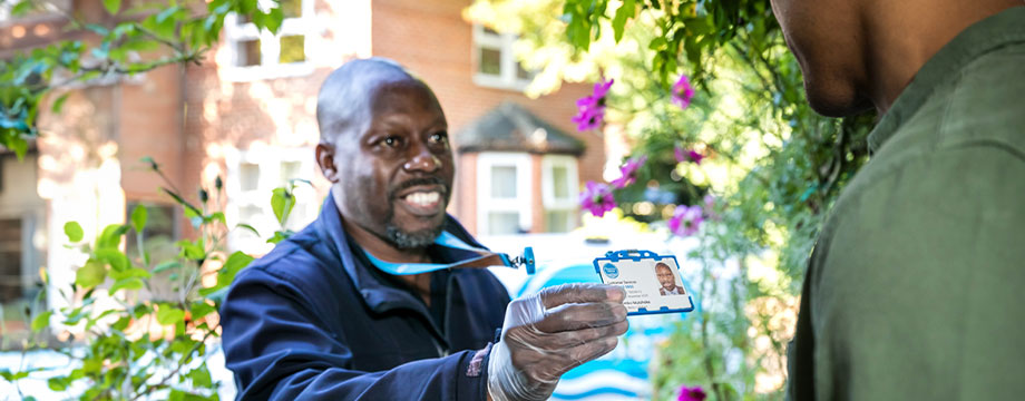 A Thames worker shows his ID badge at a customers door
