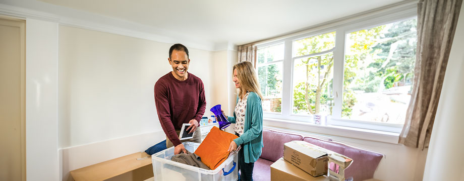 A couple unpack boxes in their home