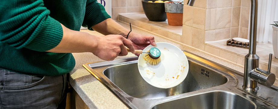 A customer washes up a plate with the tap off